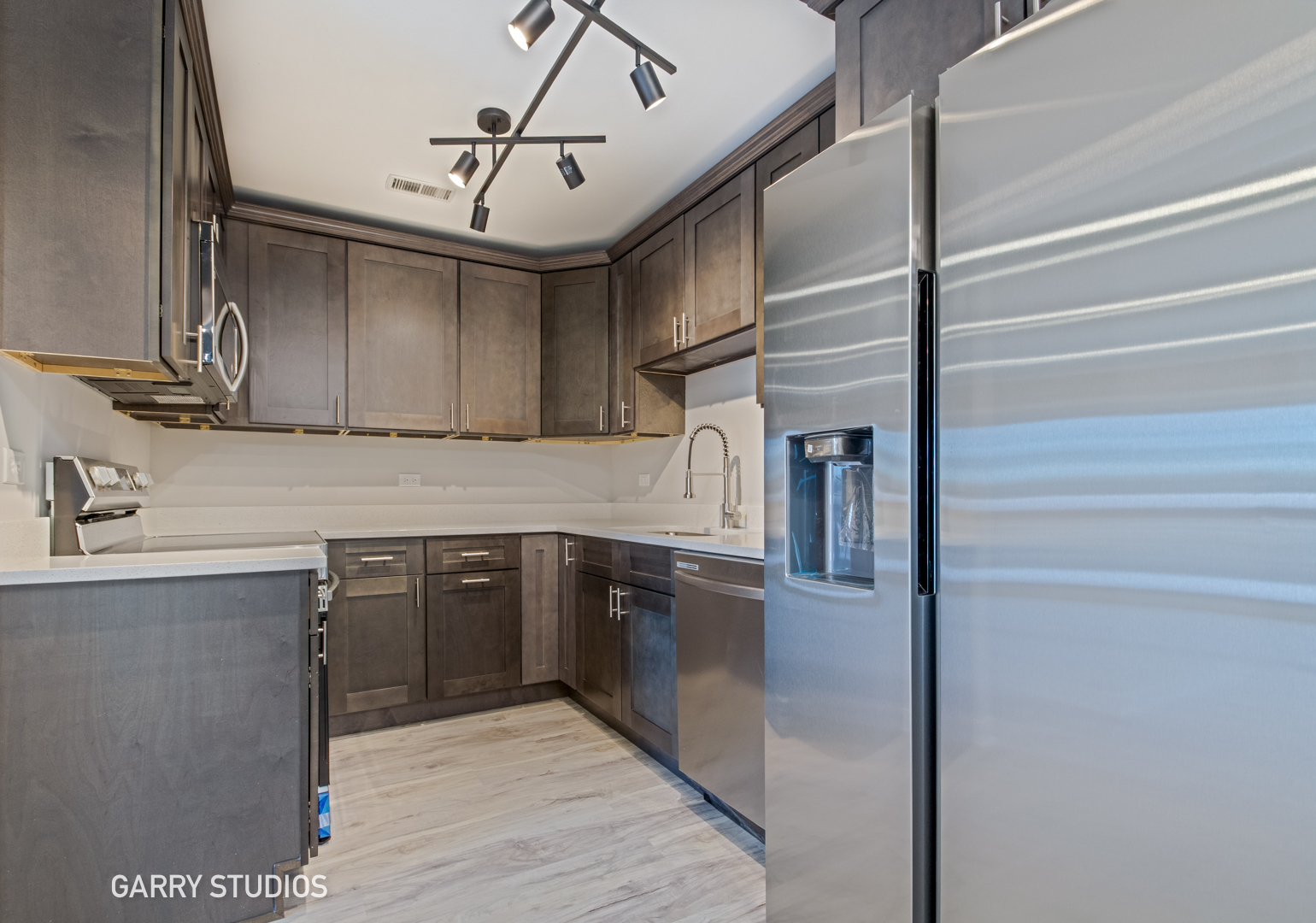 1460 Stonebridge Circle, Unit G9 Wheaton, IL 60189 - Photo 6 of 14 a kitchen with stainless steel appliances granite countertop a sink and cabinets