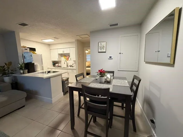 a kitchen with a dining table chairs and white cabinets