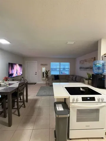 a kitchen with a stove a microwave and a dining table