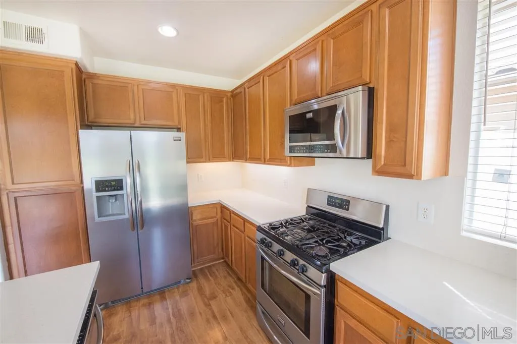3267 Dehesa Road, Unit 65 El Cajon, CA 92019 - Photo 11 of 25 a kitchen with granite countertop a refrigerator stove and microwave