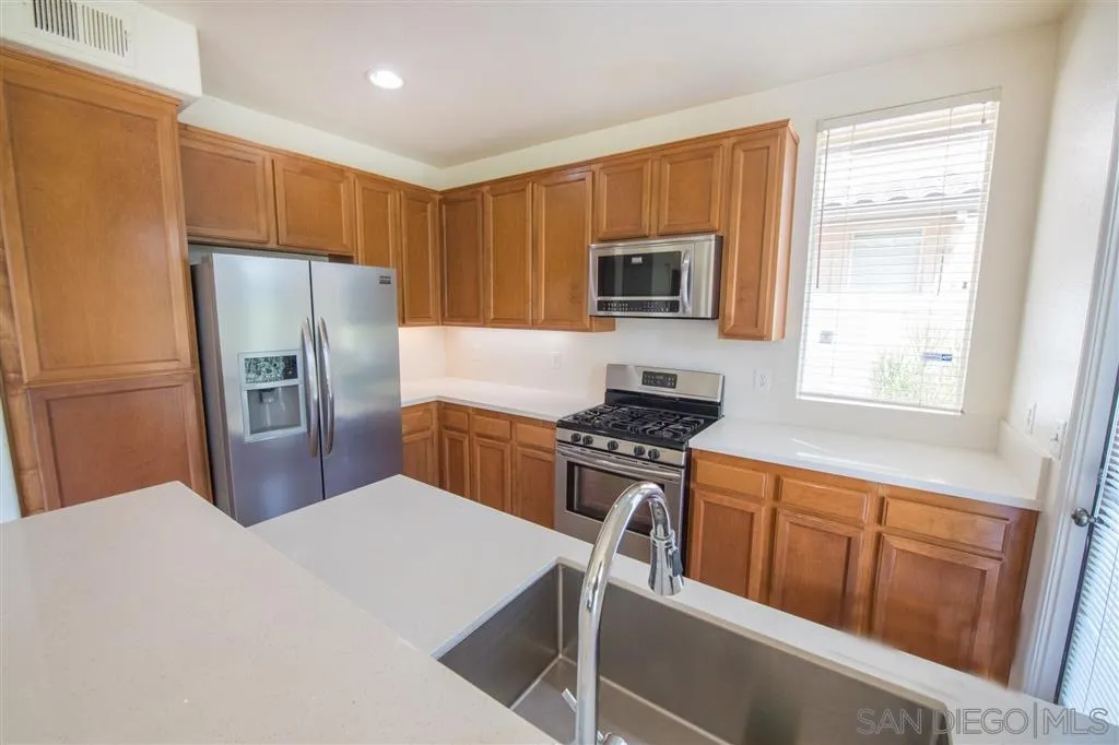 3267 Dehesa Road, Unit 65 El Cajon, CA 92019 - Photo 13 of 25 a kitchen with stainless steel appliances granite countertop a refrigerator stove top oven with a sink and dishwasher
