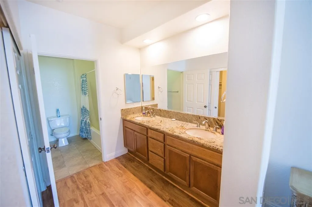 3267 Dehesa Road, Unit 65 El Cajon, CA 92019 - Photo 19 of 25 a bathroom with a granite countertop sink and a mirror