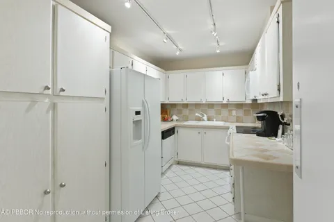 a kitchen with white cabinets and white appliances