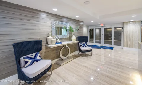 a living room with furniture a floor to ceiling window and chair