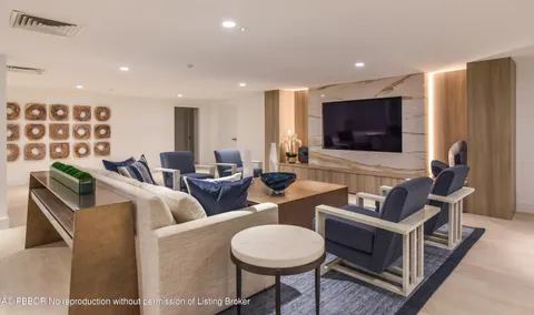 a living room with furniture a flat screen tv and kitchen view