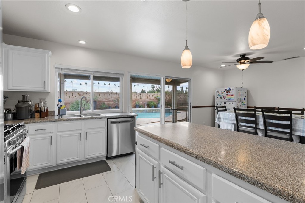 8548 Turlock Drive Riverside, CA 92504 - Photo 24 of 56 a kitchen with stainless steel appliances granite countertop a sink a stove and a wooden floors