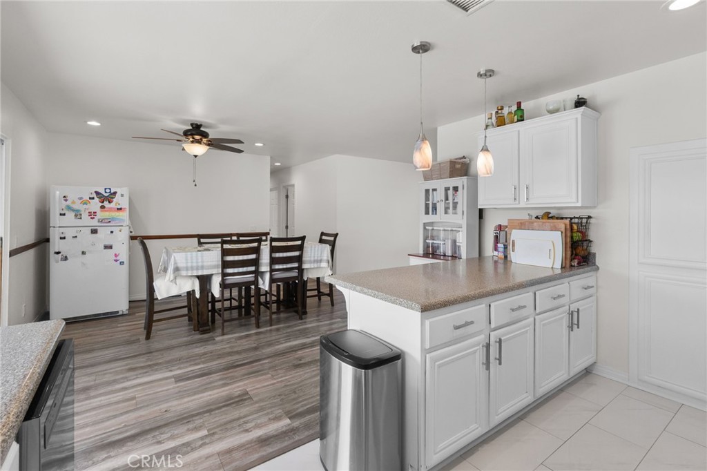 8548 Turlock Drive Riverside, CA 92504 - Photo 25 of 56 a kitchen with a table chairs and white cabinets
