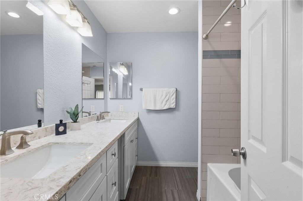 8548 Turlock Drive Riverside, CA 92504 - Photo 34 of 56 a bathroom with a double vanity sink a mirror and a bathtub