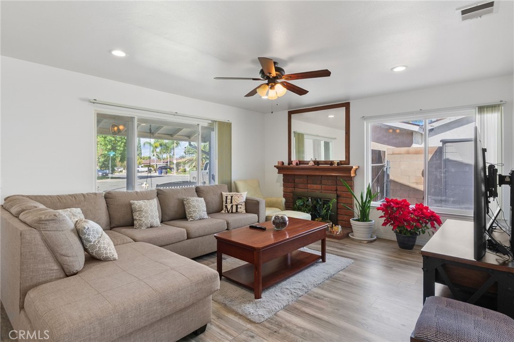 8548 Turlock Drive Riverside, CA 92504 - Photo 9 of 56 a living room with furniture a chandelier and a fireplace