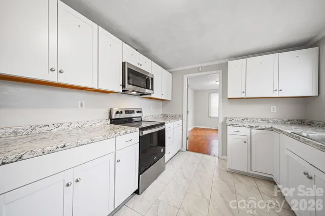 a kitchen with granite countertop cabinets stainless steel appliances a sink and a counter space