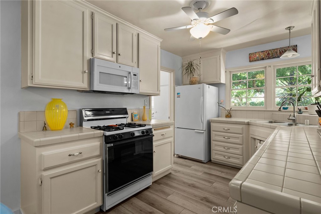 5180 Stonewood Drive Riverside, CA 92506 - Photo 17 of 49 a kitchen with appliances cabinets and a wooden floor