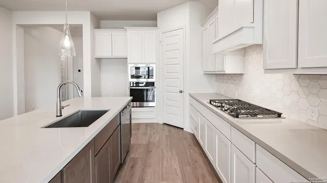 a kitchen with stainless steel appliances a sink stove and refrigerator