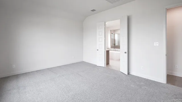 an empty room with an entryway and closet