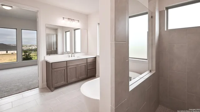 a bathroom with a tub a sink and mirror