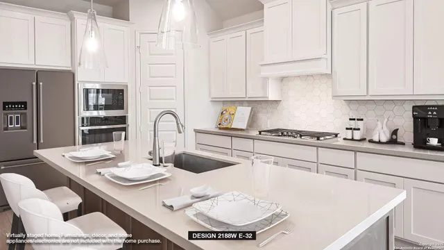 a kitchen with stainless steel appliances granite countertop a sink white cabinets a dining table and chairs