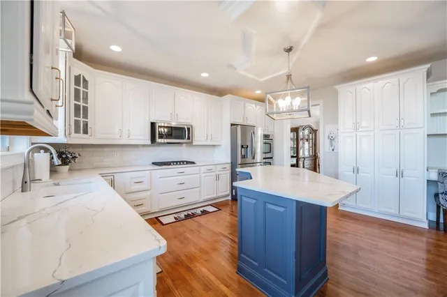 a large kitchen with stainless steel appliances lots of counter space and wooden floor