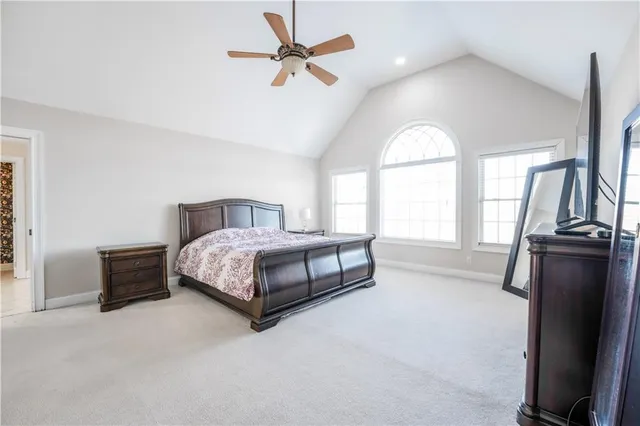 a spacious bedroom with a bed and a chandelier