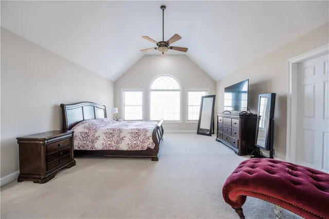 a spacious bedroom with a bed a couch and a chandelier