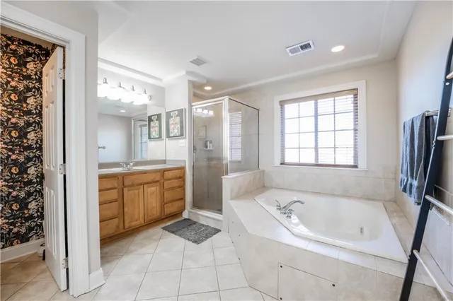 a spacious bathroom with a bathtub sink and mirror