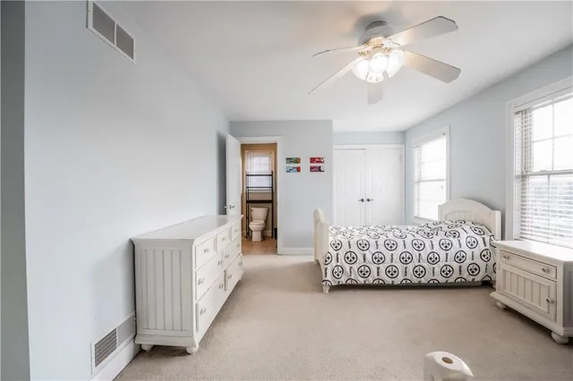 a spacious bedroom with a bed and a chandelier
