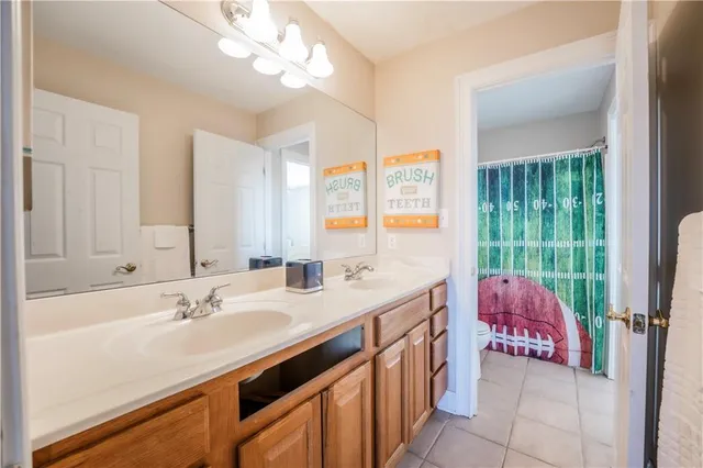 a en suite bathroom with a double vanity sink large mirror and vanity