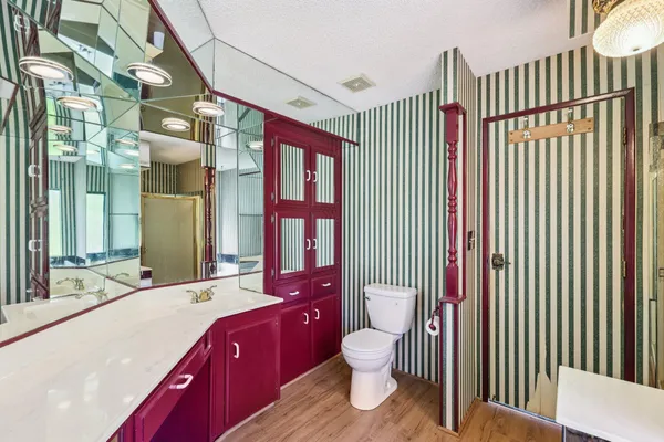 a spacious bathroom with a toilet a sink and a mirror