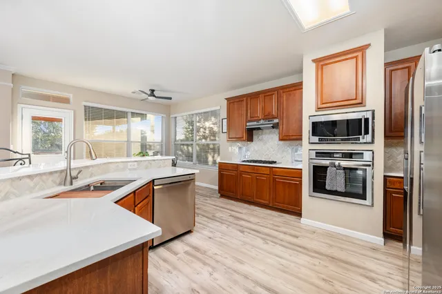 a kitchen with stainless steel appliances granite countertop a stove a sink and a refrigerator