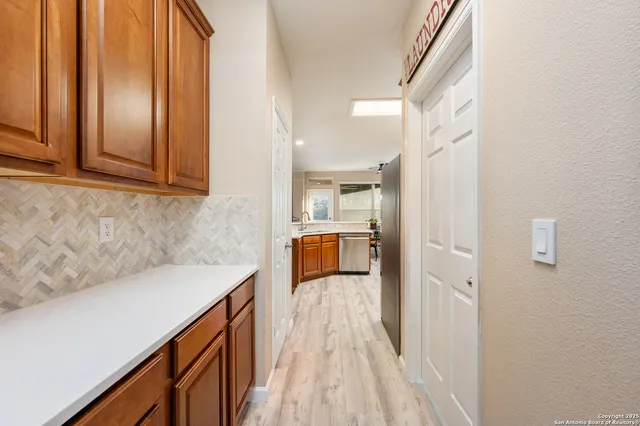 a hallway with a sink and wooden floor