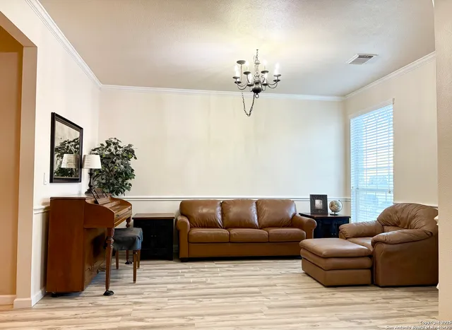 a living room with furniture chandelier and a window