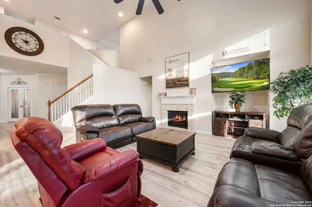 a living room with furniture fireplace and a large window