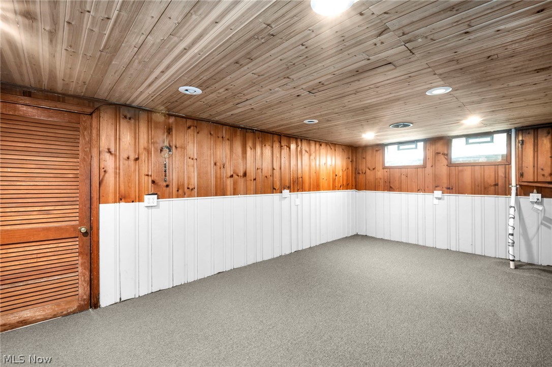2313 North Taylor Road Cleveland Heights, OH 44112 - Photo 27 of 32 Finished room featuring wood-panel walls with white wainscoting, wood-finish ceiling, recessed lighting, and carpet flooring