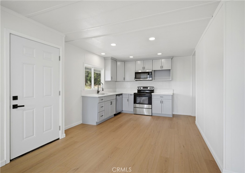59995 Granite Gulley Road Anza, CA 92539 - Photo 7 of 33 a kitchen with white cabinets and stainless steel appliances