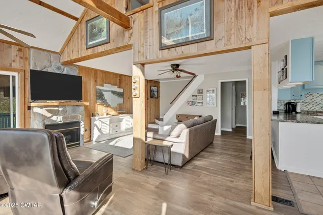 a living room with furniture a flat screen tv and kitchen view