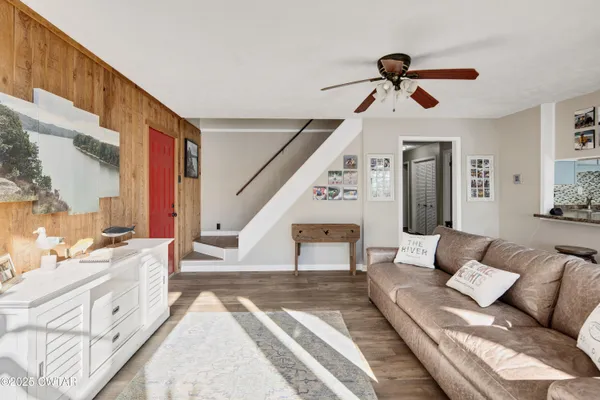 a living room with furniture and a ceiling fan