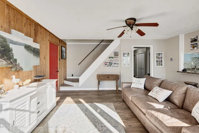a living room with furniture and a ceiling fan