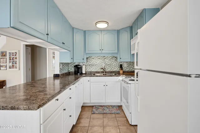 a kitchen with stainless steel appliances granite countertop a sink and a refrigerator