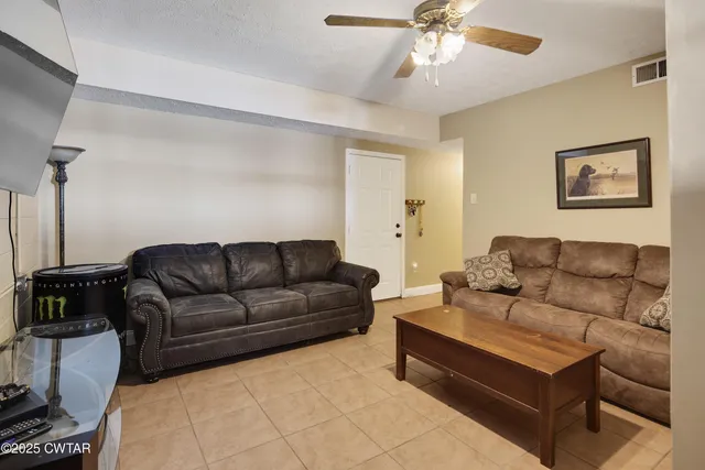 a living room with furniture and a ceiling fan