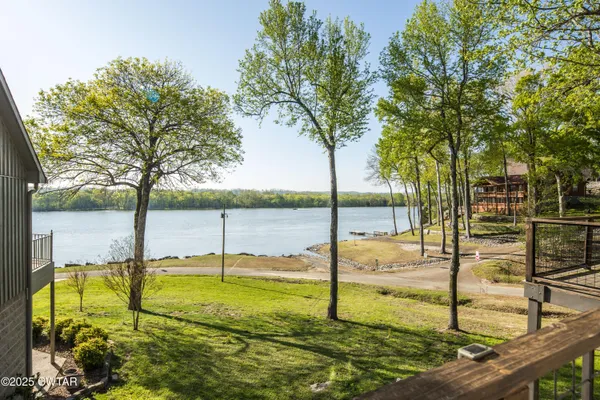 a view of a balcony with wooden floor next to a iron stairs