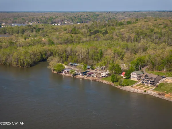 an aerial view of ocean and residential houses with outdoor space