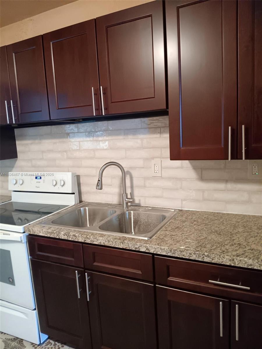 1825 Northwest 112th Street Miami, FL 33167 - Photo 16 of 24 a kitchen with granite countertop stainless steel appliances and cabinets