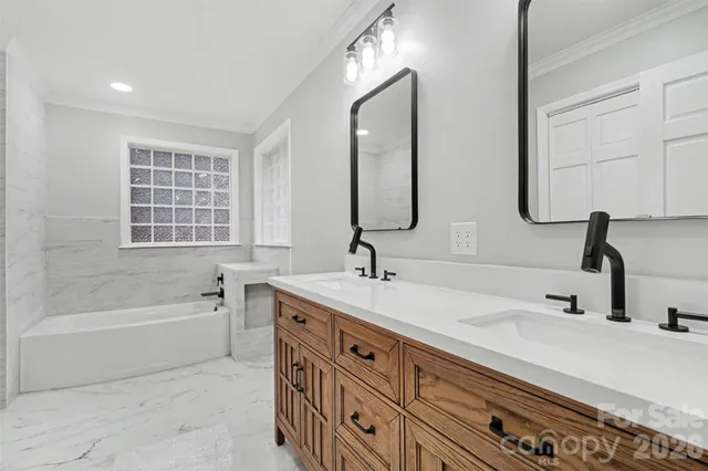 a bathroom with a double vanity sink double mirror and bathtub