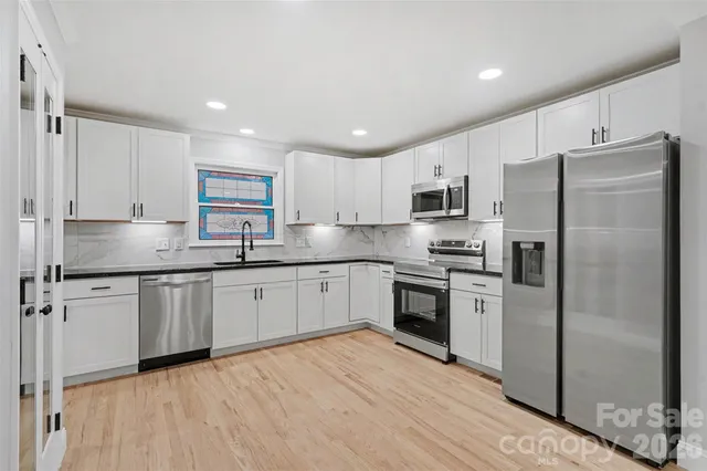 a kitchen with stainless steel appliances granite countertop a refrigerator stove microwave and sink