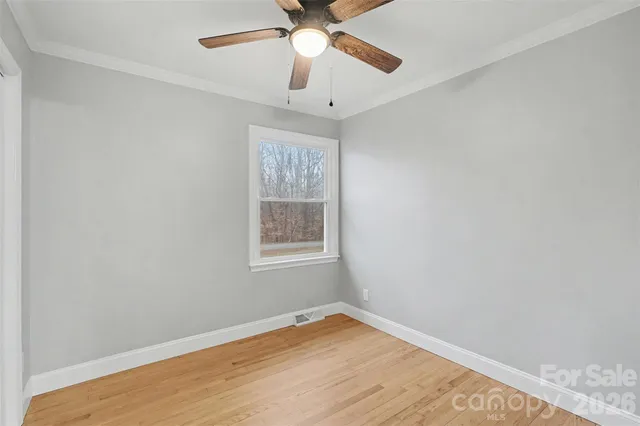 an empty room with a window and a fan
