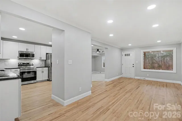a view of kitchen with cabinets stainless steel appliances and wooden floor