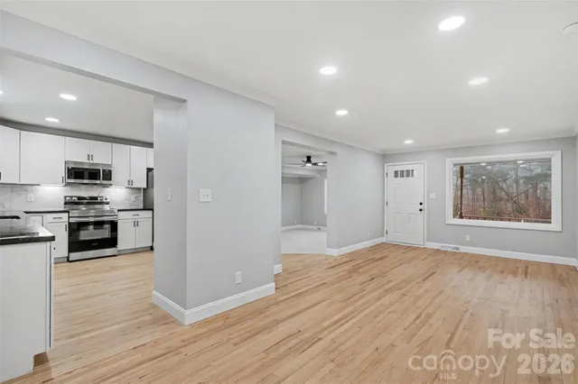 a view of kitchen with cabinets stainless steel appliances and wooden floor