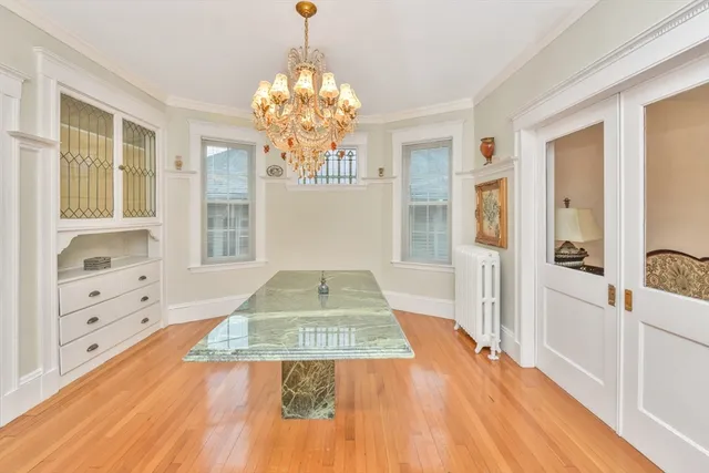 a view of a hallway with wooden floor and chandelier