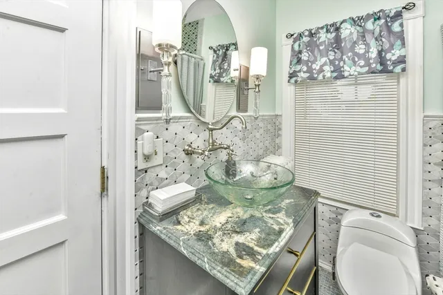 a bathroom with a granite countertop bathtub sink and toilet