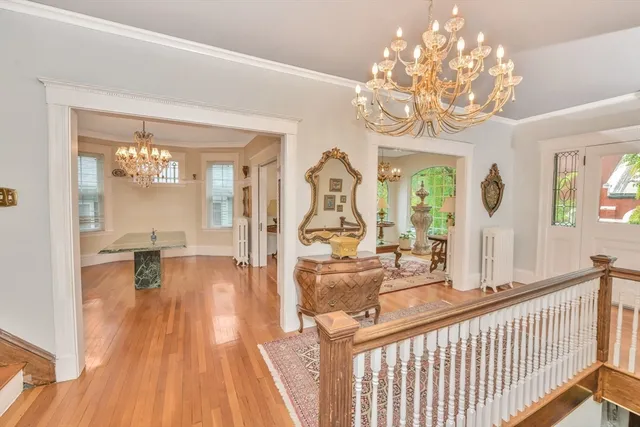 a view of a dining room with furniture a chandelier and wooden floor