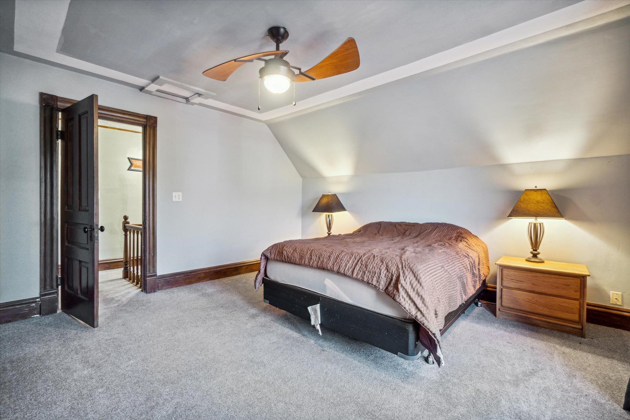 14188 Beloit Road Caledonia, IL 61011 - Photo 21 of 42 a spacious bedroom with a bed and a chandelier