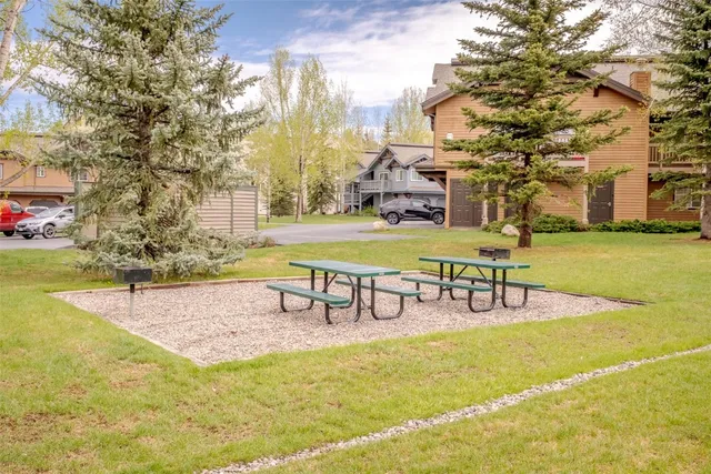 a view of a swimming pool with lawn chairs and wooden fence